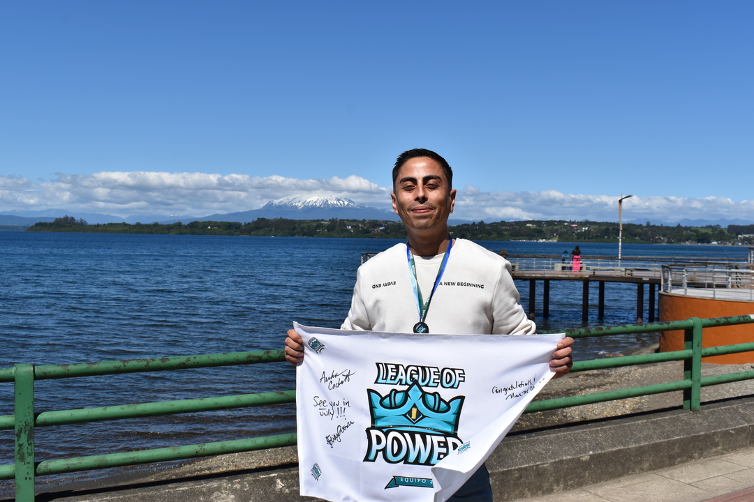 Participante del curso sosteniendo bandera frente al Lago