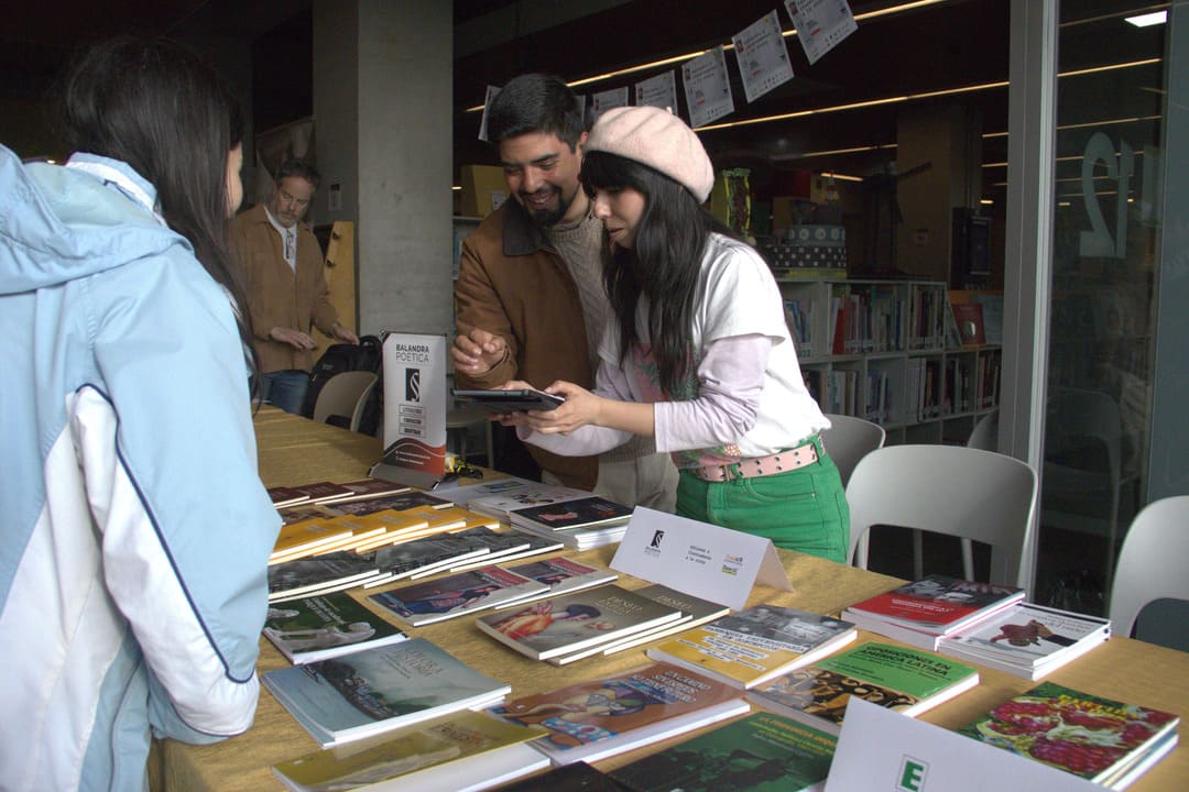 Chica atendiendo puesto de libros en encuentro editorial A la Vista