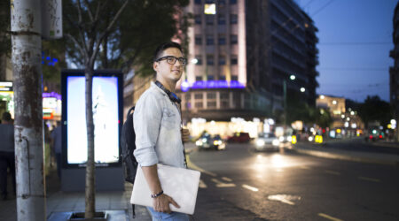 joven estudiante cargando una computadora en la calle